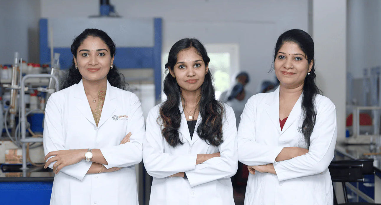 Three Sitaram Ayurveda Europe women in lab coats standing in a laboratory setting